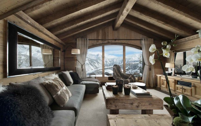Naturmaterialien, Wanddekoration mit Holz, Deckenbalken, Holzmöbel und Kissen aus Fellen und Pelzen