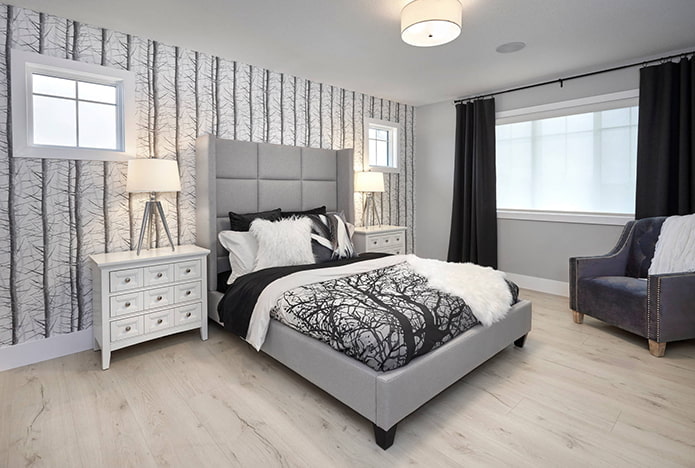 graues Bett und schwarze Vorhänge
