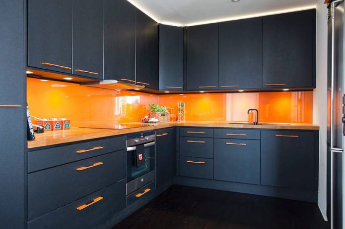Schwarzes Eckset mit orangefarbener Schürze