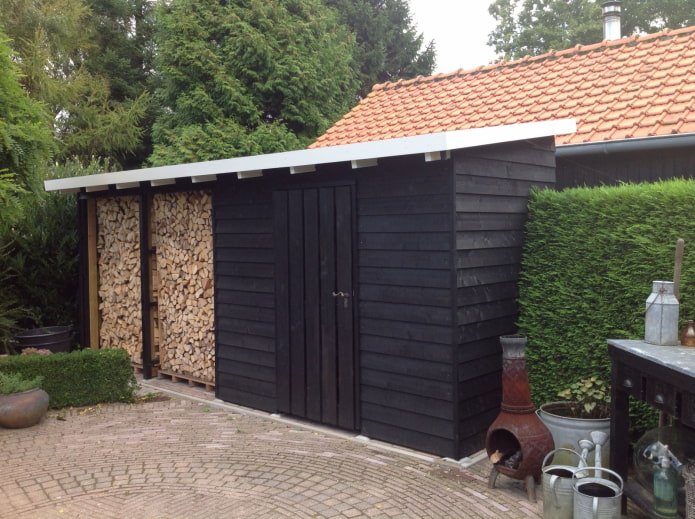 Holzschuppen in der Nähe der Hauswand
