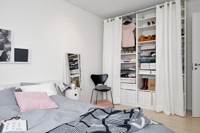 kleines Schlafzimmer mit Ankleidezimmer hinter Vorhängen