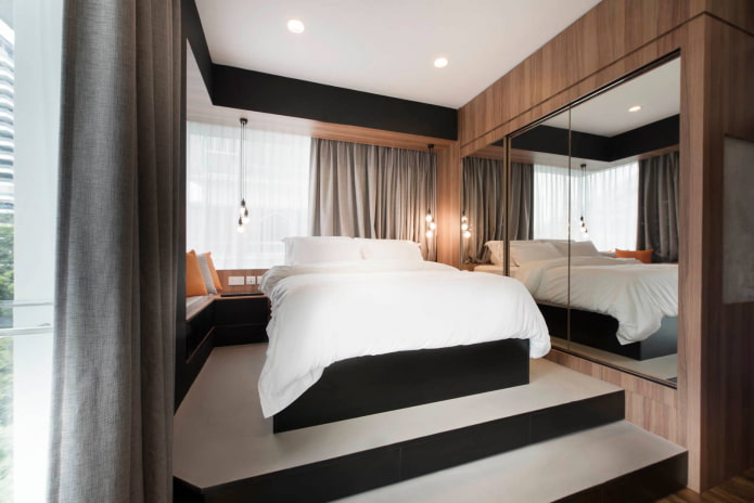 Bett auf erhöhtem Podest mit seitlichem Spiegel