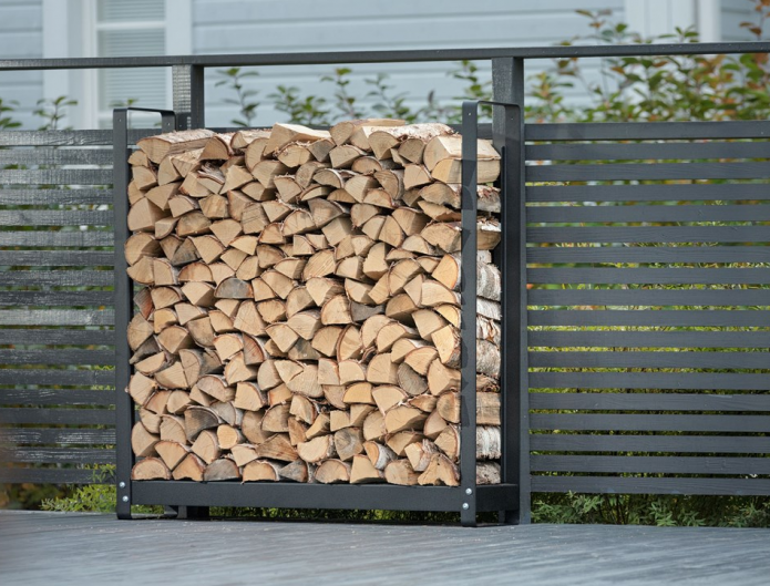 Holzstapel neben einem Metallzaun