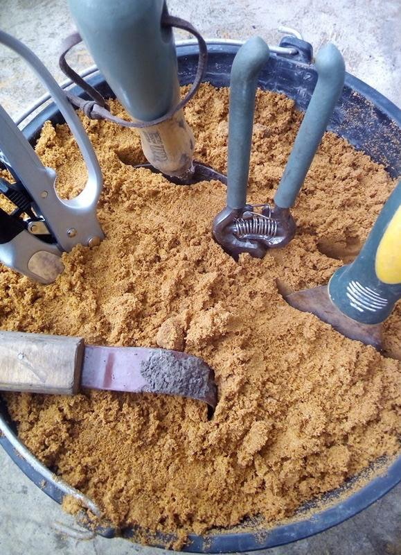 Werkzeuge in einem Eimer mit Sand