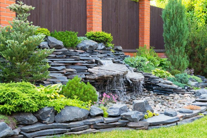 Terrassenhang mit Nadelbäumen und einem Wasserfall