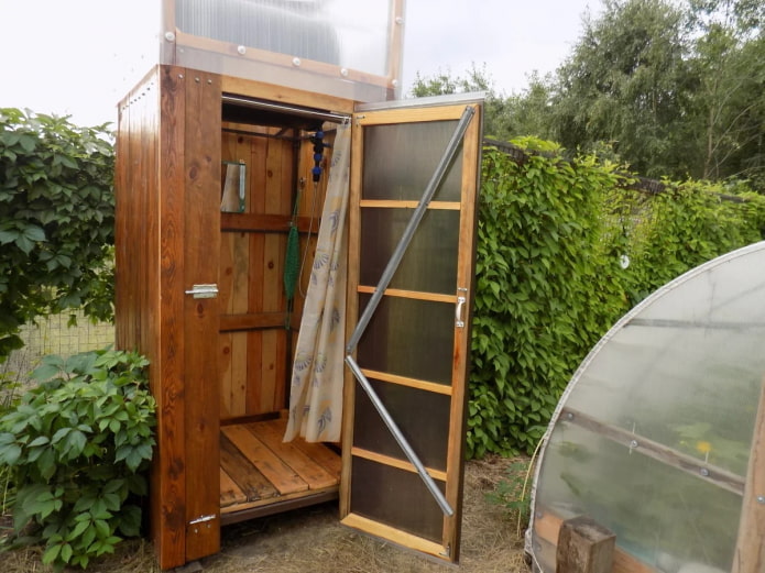 Sommerdusche aus Holz auf dem Land