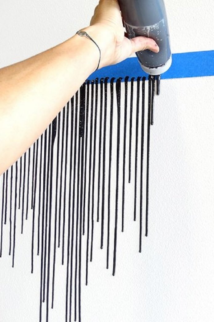 ein Streifen schwarzer Farbe tropft an der Wand