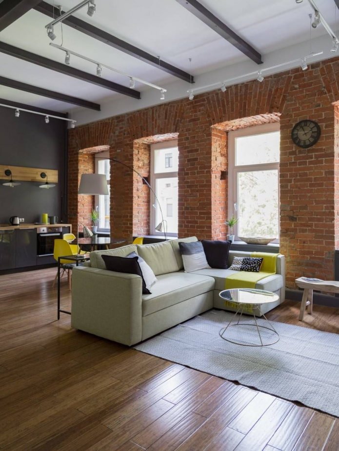 Schrägen und rote Ziegelwand in einem Loft-Wohnzimmer