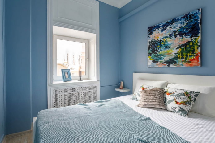 weiße Fenstergruppe mit Stuckleisten in einem blauen Schlafzimmer