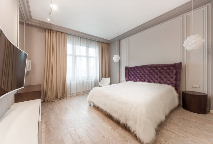 Bett mit weißer Tagesdecke im Schlafzimmer