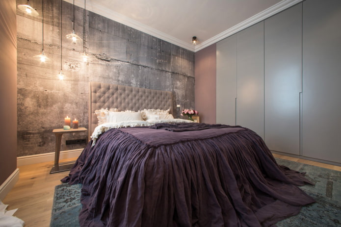 Bett mit lila Tagesdecke im Schlafzimmer
