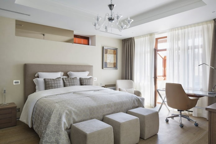 Bett mit grauer Tagesdecke im Schlafzimmer