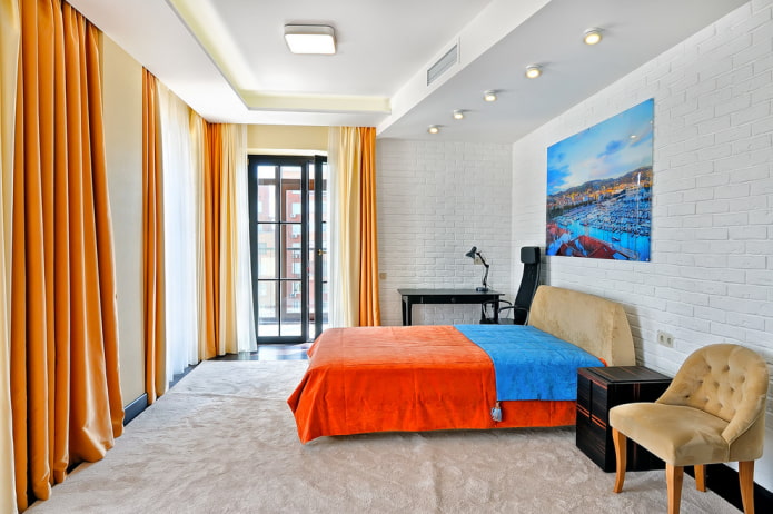 Bett mit einer orangefarbenen Tagesdecke im Schlafzimmer