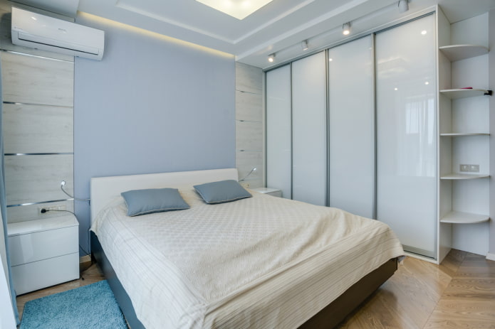 weißer Kleiderschrank mit Schiebetüren in einem Schlafzimmerinterieur