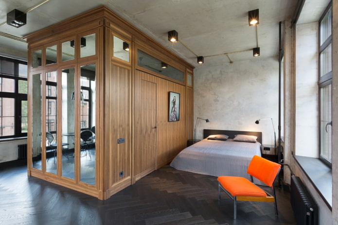 ein Kleiderschrank in Form einer Trennwand in einem Interieur im Loft-Stil