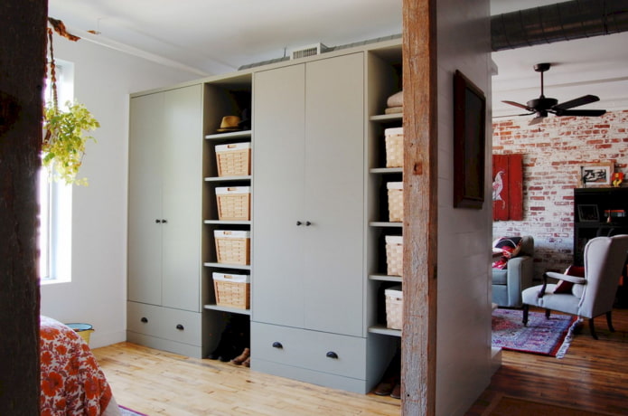 ein Kleiderschrank in Form einer Trennwand in einem Interieur im Loft-Stil