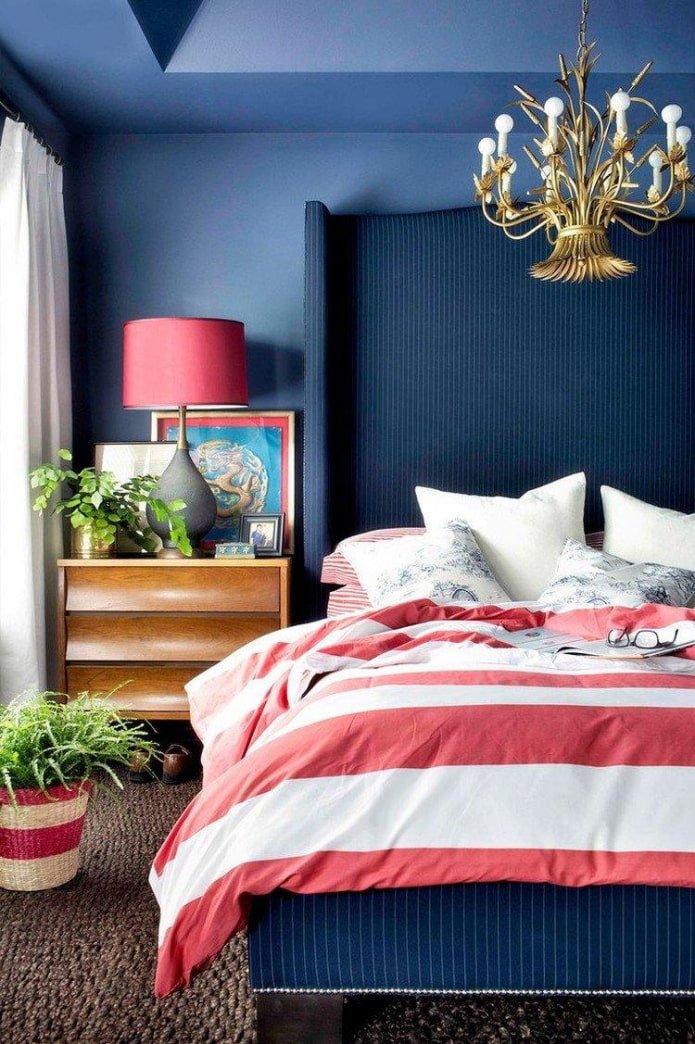 ein blaues Schlafzimmer mit roten Akzenten
