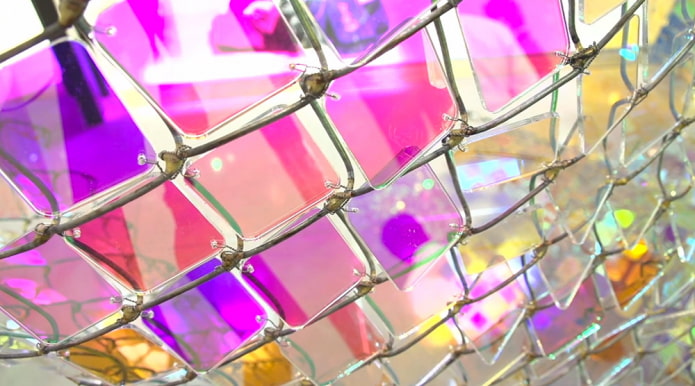 Farbiges Glas auf einem Maschendrahtzaun