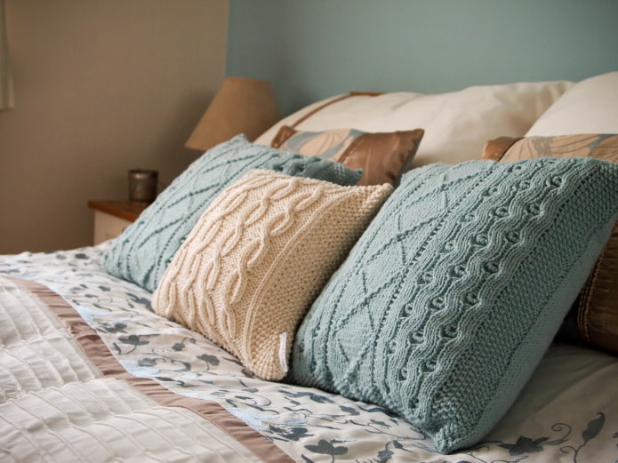 Gestrickte Kissen auf dem Bett