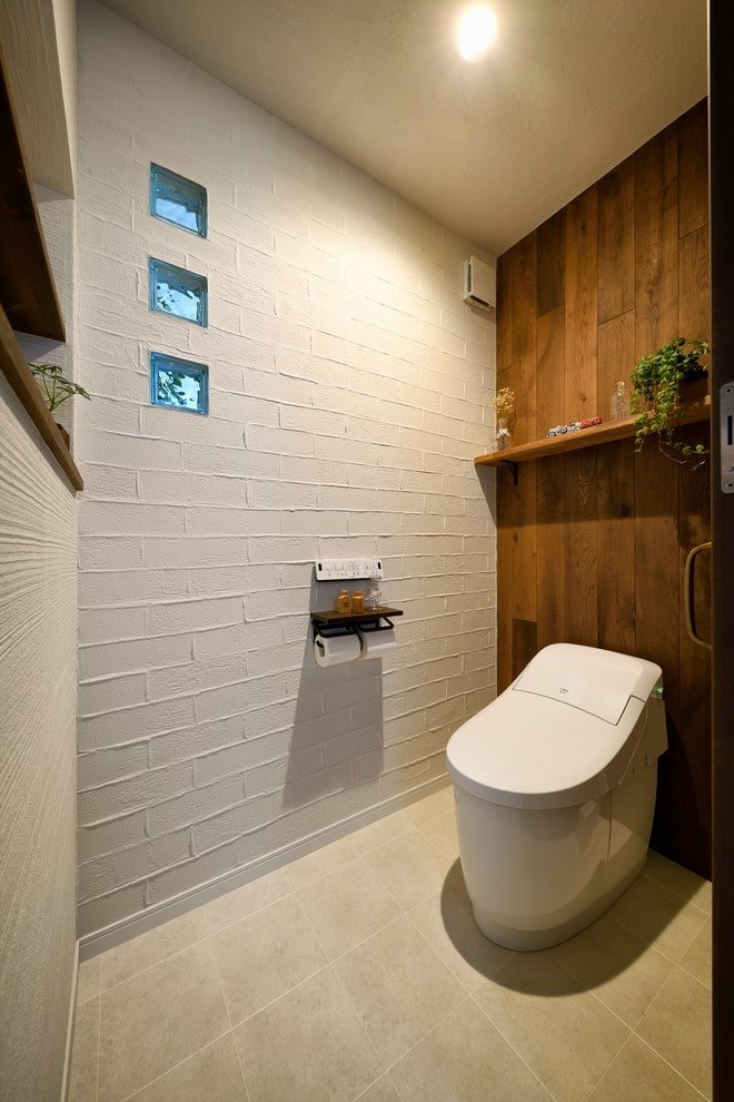 Weiße Toilette mit einer hölzernen Zwischenwand