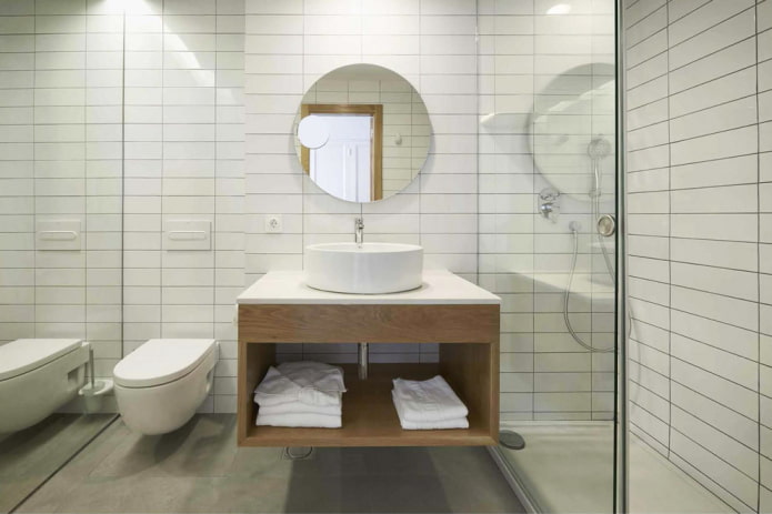 Weißes Badezimmer mit Dusche und Hängeschrank