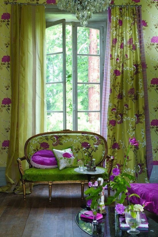Sofa mit grünem Bezug und Blumen im Innenraum