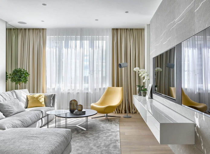 Silbergraues Wohnzimmer mit hellgelben Sesseln und Sofakissen